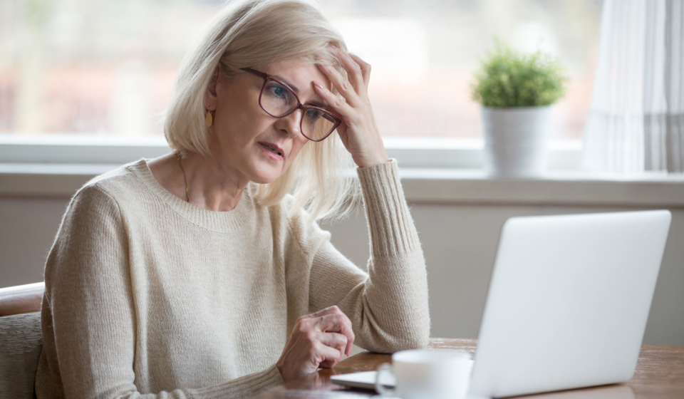 Thoughtful confused mature business woman concerned thinking about online problem looking at laptop, frustrated worried senior middle aged female reading bad email news, suffering from memory loss