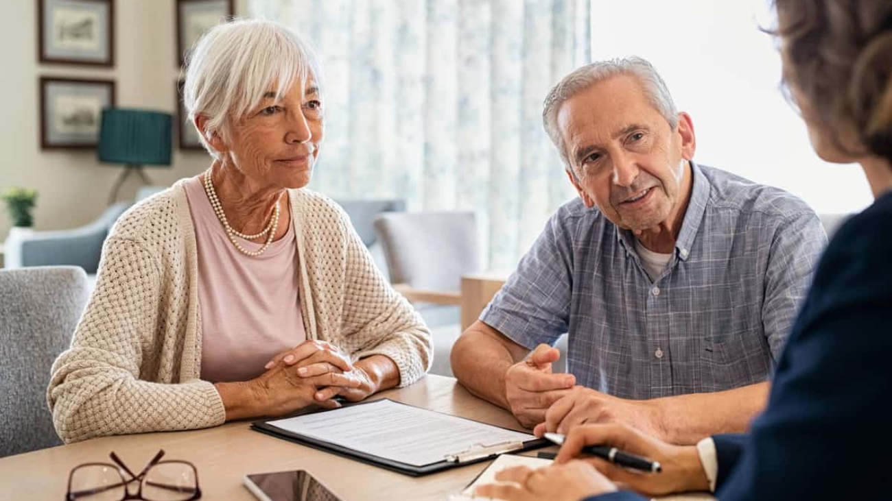 Senior man and woman meeting medical adviser for health insurance at home. Old couple planning their investments with financial advisor after retirement at home. Aged couple consulting with insurance agent while sitting together with prospectus at home.