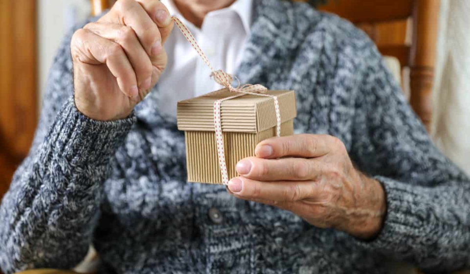 an elderly gentleman opens a birthday present